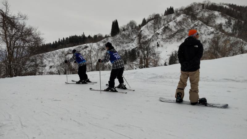 スキー教室で先生とゲレンデを滑る生徒