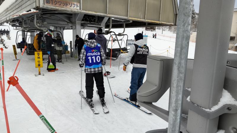 スキー教室でインストラクターとリフトに乗ろうとする生徒