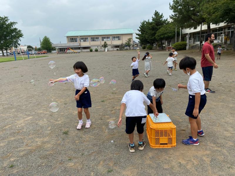 校庭でしゃぼん玉をする児童