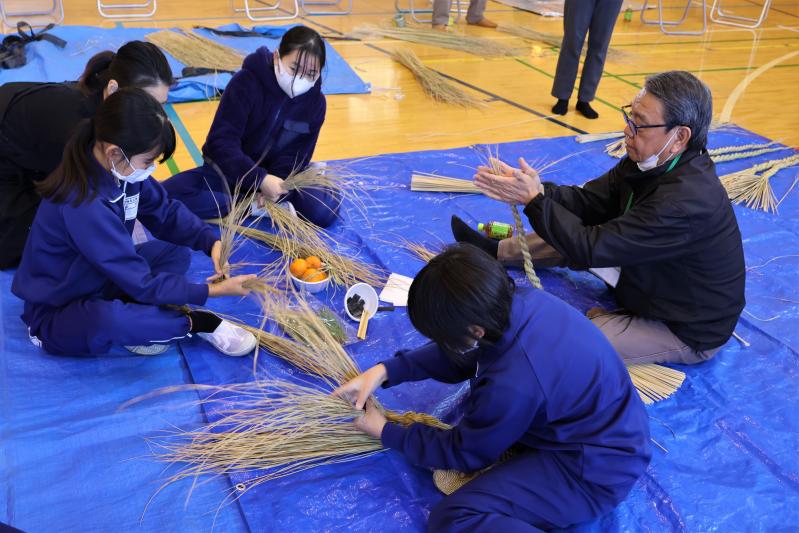 地域の方と一緒にしめ縄を作る児童達