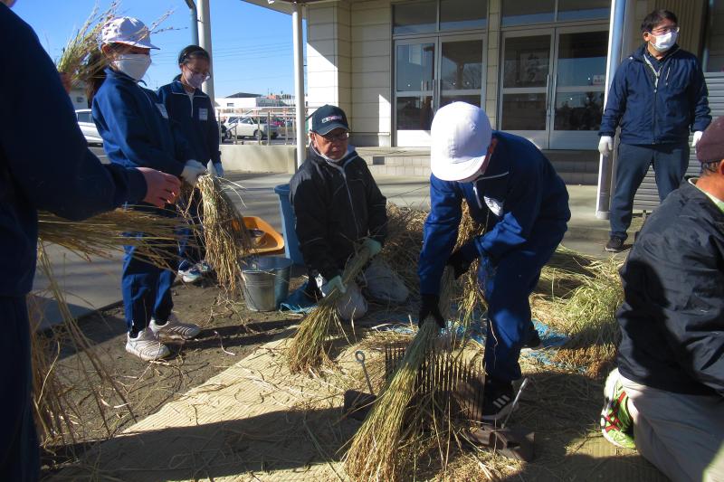 脱穀作業をする児童達