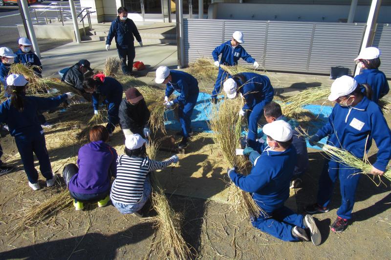 脱穀作業をする児童達